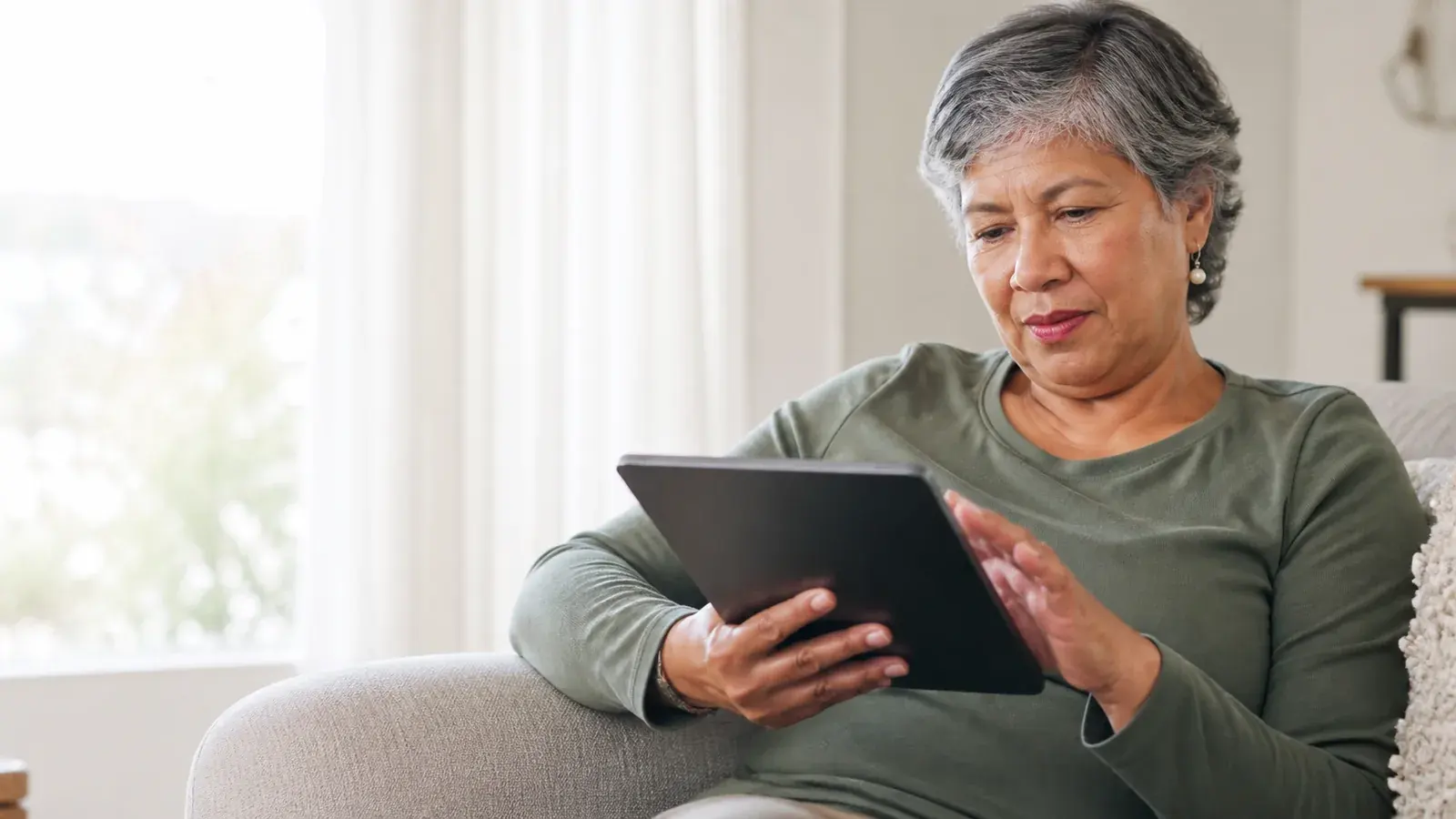 Mature adult reviewing general information on a tablet at home